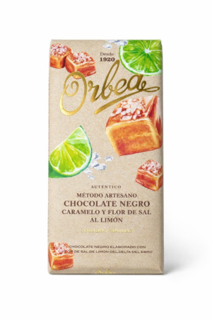 Tableta de chocolate negro artesanal Orbea, elaborada en Navarra con caramelo cremoso, flor de sal y toque de limón del Delta del Ebro. Un equilibrio perfecto entre dulzor, frescor y textura crujiente, ideal para los amantes del cacao intenso.