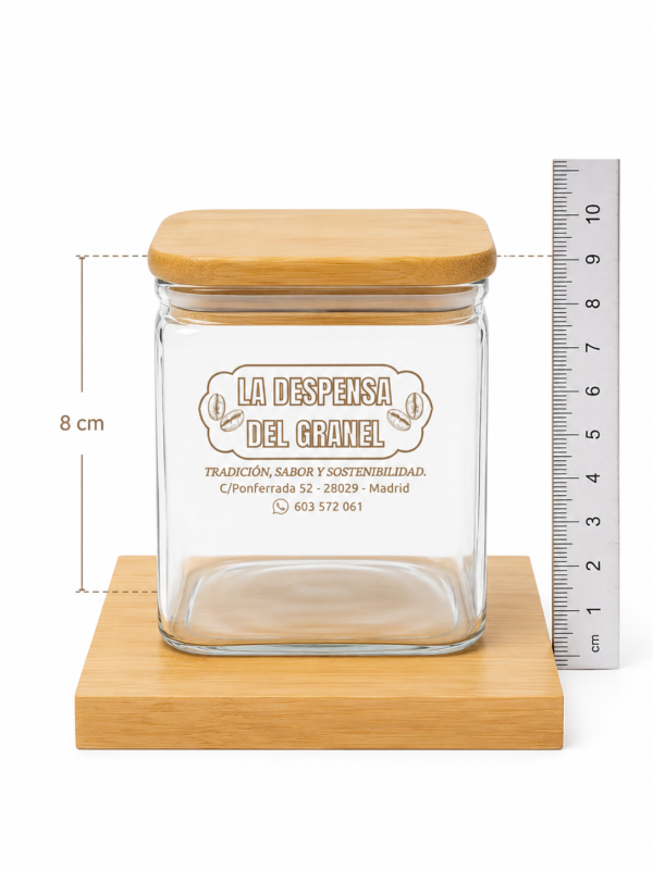 Tarro de Cristal con Tapa de Bambú y Base de Madera – 8×8×8 cm Este tarro de cristal con tapa de bambú y base de madera, en tamaño 8 cm × 8 cm × 8 cm, es perfecto para almacenar ingredientes más grandes o en mayor cantidad. Su diseño limpio, moderno y sostenible lo convierte en una pieza ideal para cualquier cocina, despensa o espacio de organización. Materiales de alta calidad Cristal grueso y resistente, apto para alimentos y libre de BPA. Tapa de bambú natural, sostenible y segura para el contacto con alimentos. Cierre hermético que mantiene tus ingredientes frescos, secos y protegidos. Base de madera incluida, que aporta estabilidad y un acabado elegante. Diseño moderno y funcional Su tamaño de 8×8×8 cm ofrece mayor capacidad que los tarros pequeños, ideal para ingredientes de uso frecuente. El cristal transparente permite ver el contenido fácilmente, aportando orden y estética a tu cocina. Incluye etiqueta personalizada